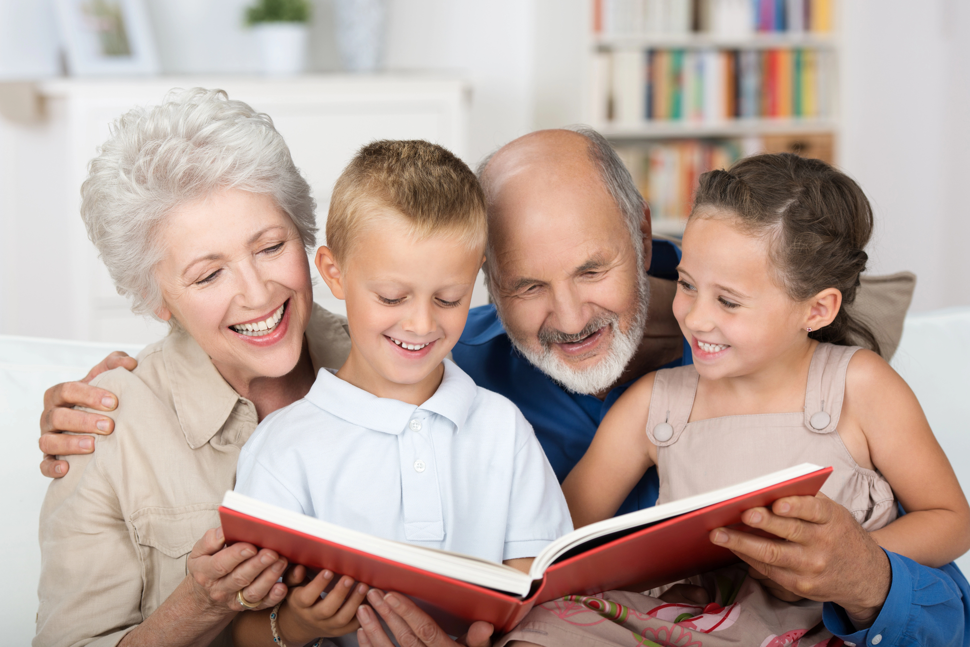 Grand parents with grandchildren reading a book